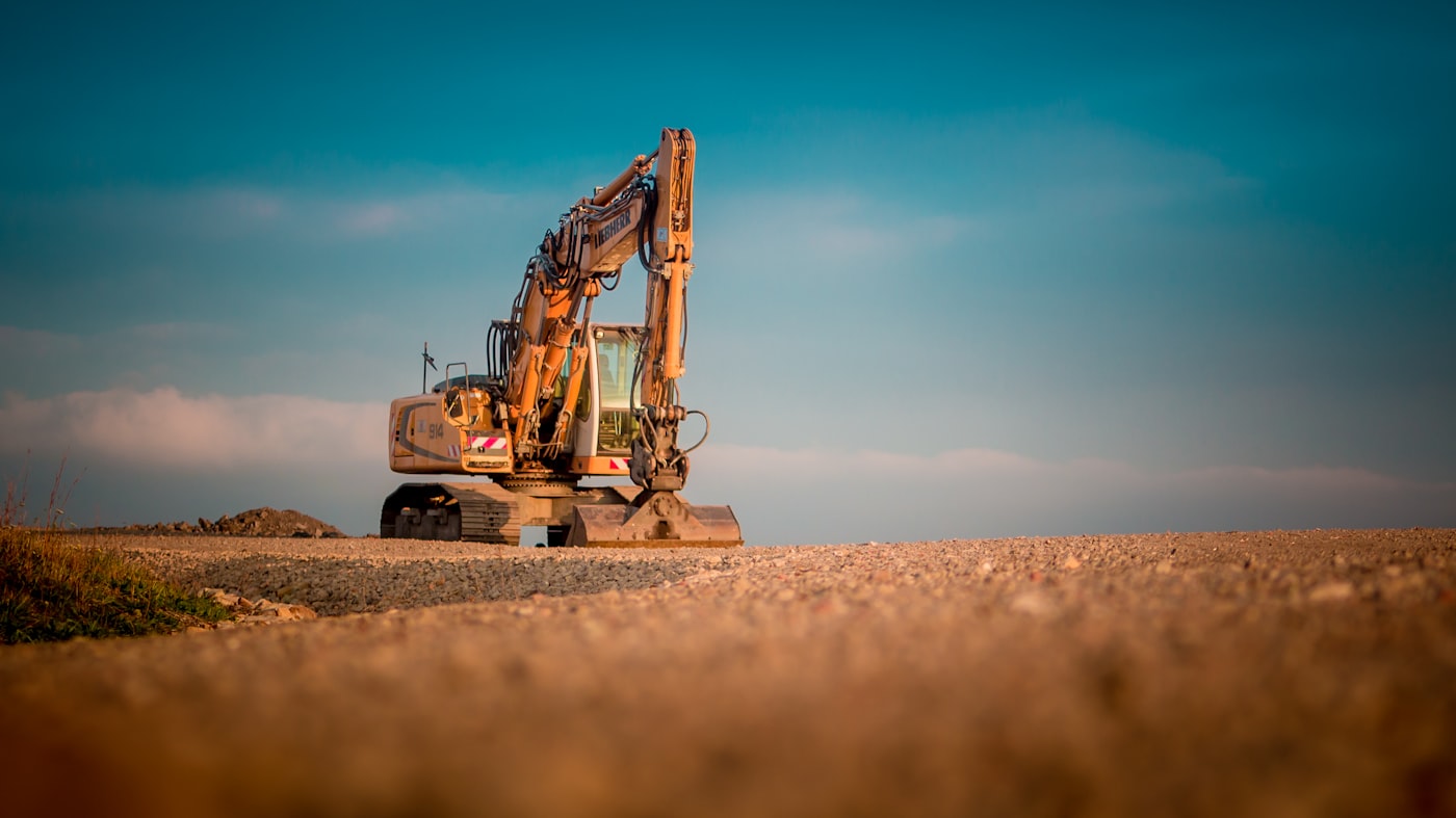 Yellow excavator on a graded gravel site — excavating contractor Belgrade, MT