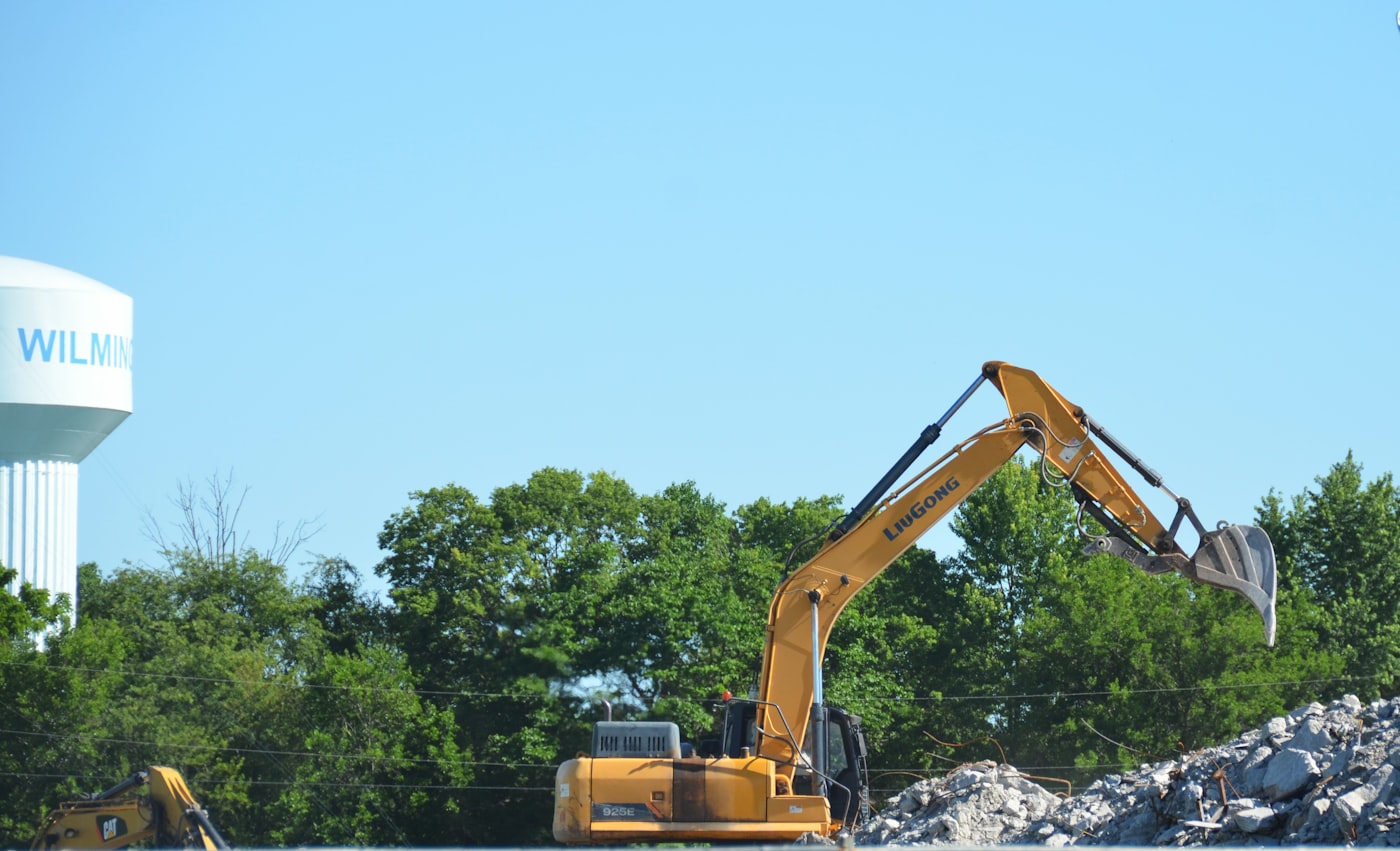 Excavator clearing demolition debris and concrete rubble in Gallatin County, MT